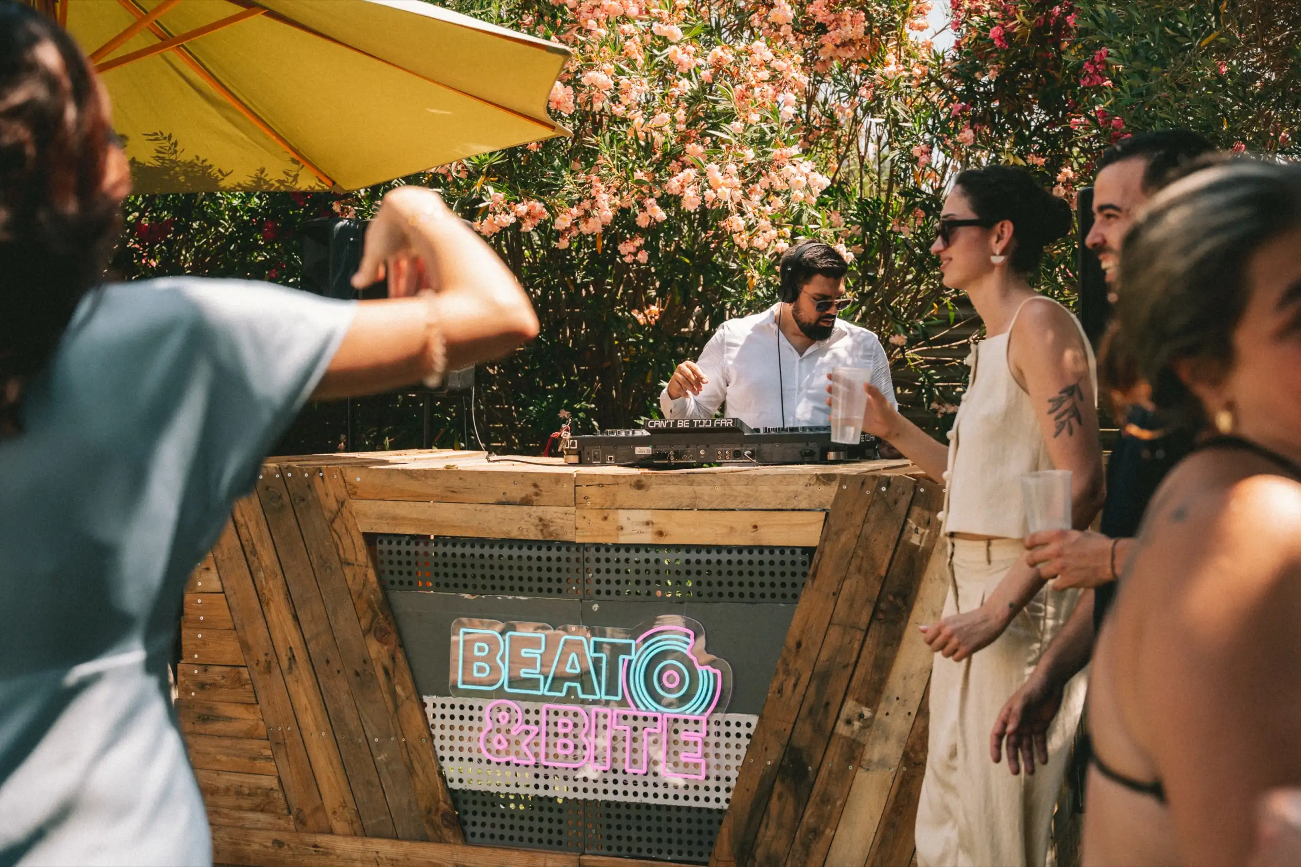 DJ con cascos en la cabina de madera de Beat&Bite durante una celebración en un jardín