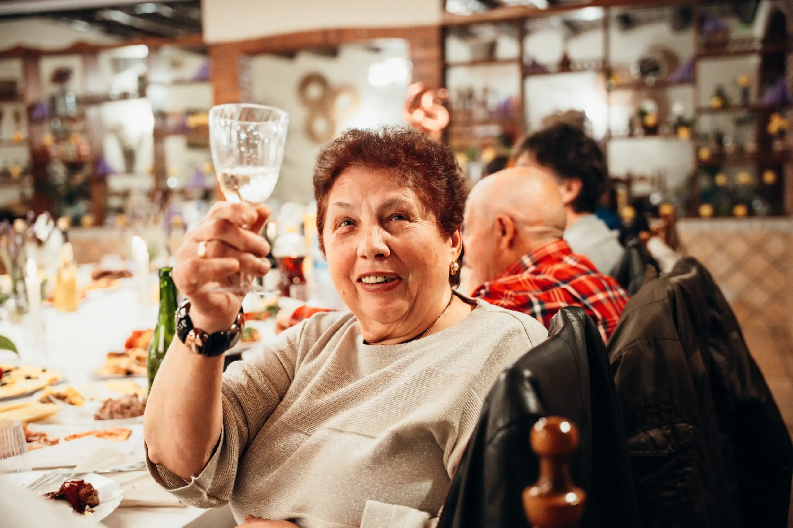Una invitada levanta su copa y sonríe durante el brindis